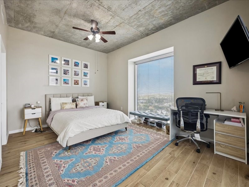 5925 Almeda Road, Unit 12202 Houston, TX 77004 - Photo 5 of 33 Versatile primary bedroom offers plenty of space for guests, a home office, or a flex room. Large windows provide abundant natural light, while the industrial concrete ceiling adds modern character.
