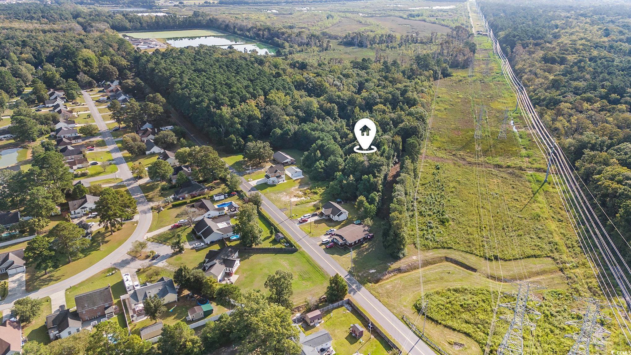 Aerial view of property and surrounding area featuring nearby suburban area