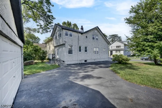 a view of a house with a yard and pathway