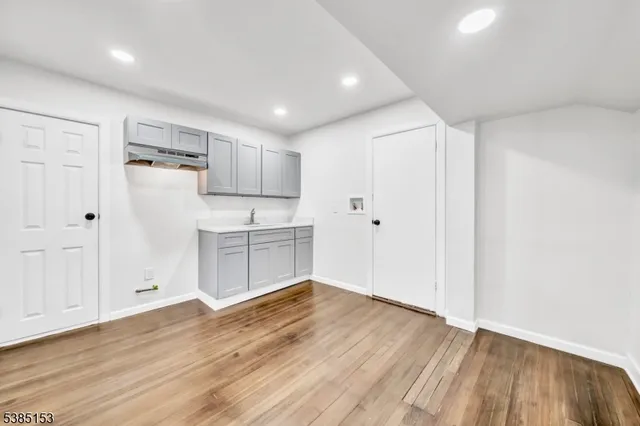 a view of a kitchen with white cabinets and wooden floor