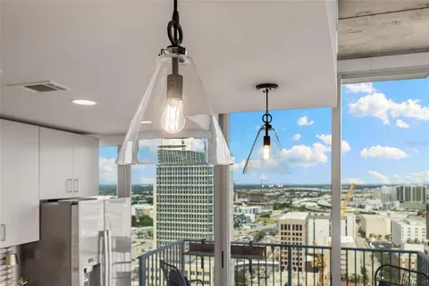 a kitchen with refrigerator a stove a sink a dining table and chairs