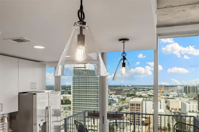 a kitchen with refrigerator a stove a sink a dining table and chairs