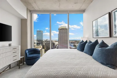 a bedroom with a large bed and a chandelier
