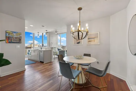 a dining room with wooden floor a glass table and chairs
