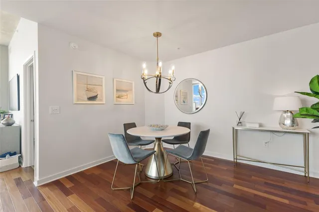 a view of a dining room with furniture a chandelier and wooden floor