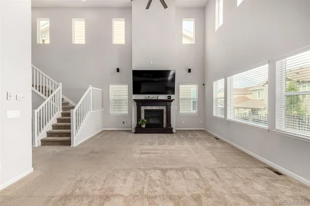 a view of a livingroom with a fireplace staircase and windows