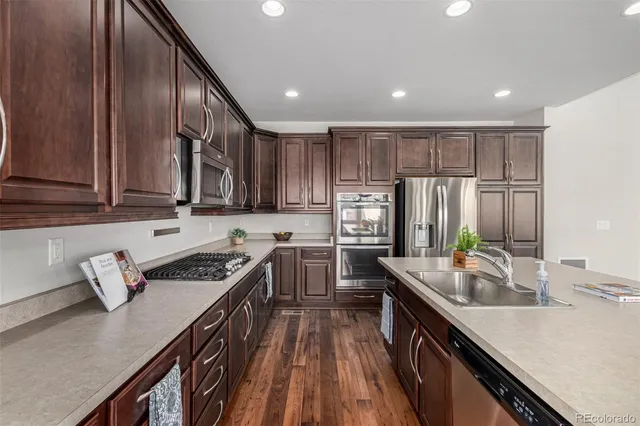 a kitchen with stainless steel appliances granite countertop sink stove top oven and cabinets