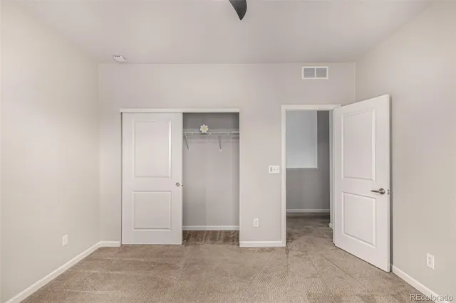 an empty room with windows and closet