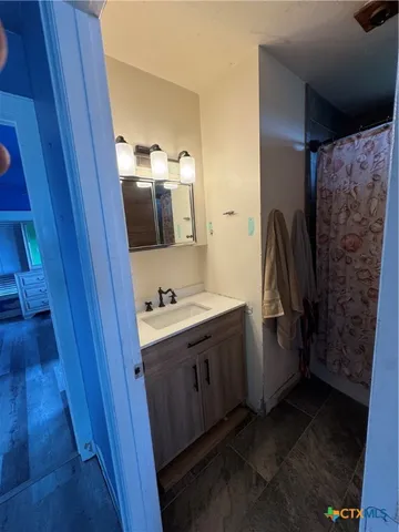 a bathroom with a sink and mirror with toilet