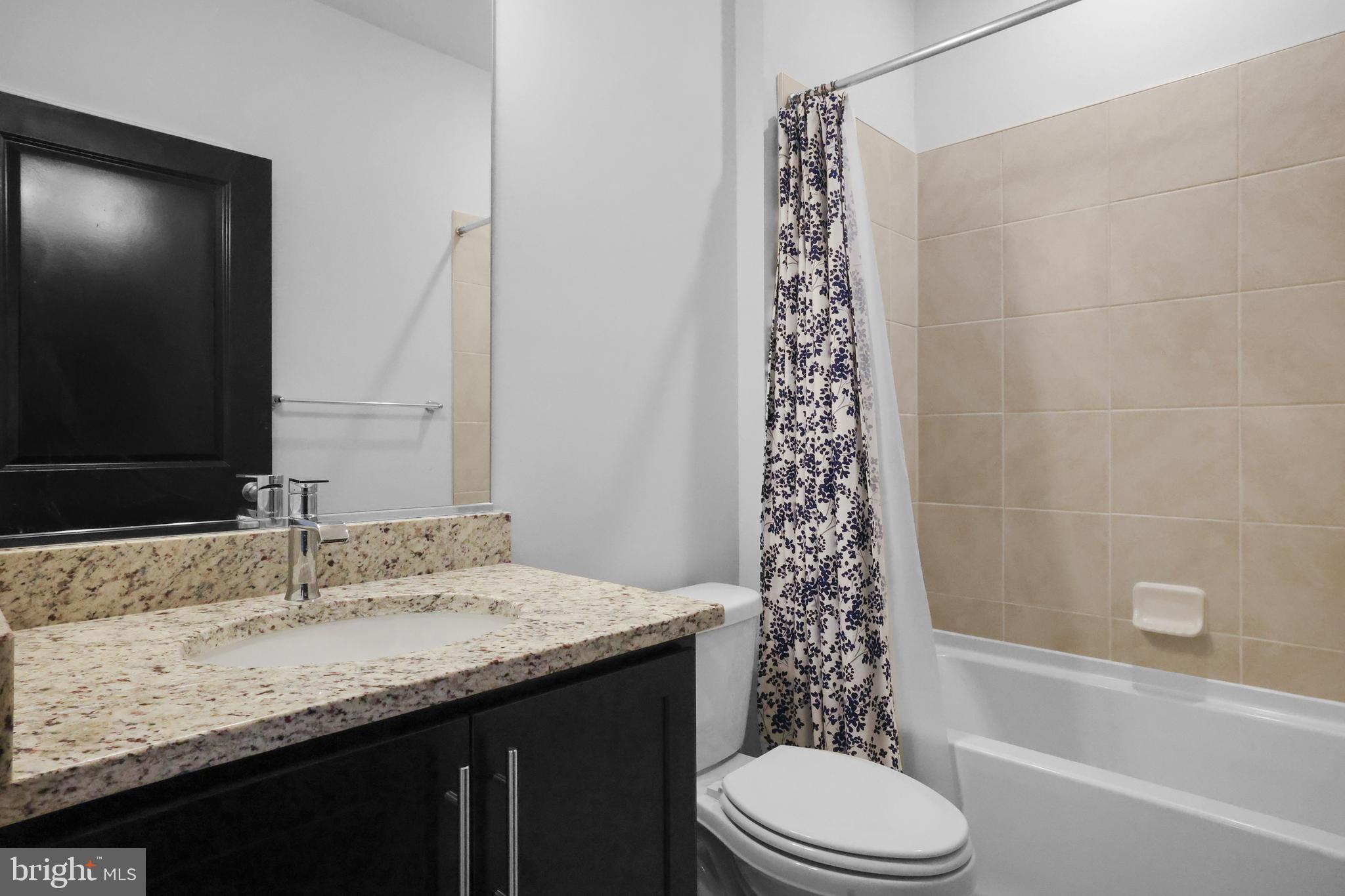 854 Amity Street Frederick, MD 21701 - Photo 30 of 62 a bathroom with a granite countertop sink toilet and shower