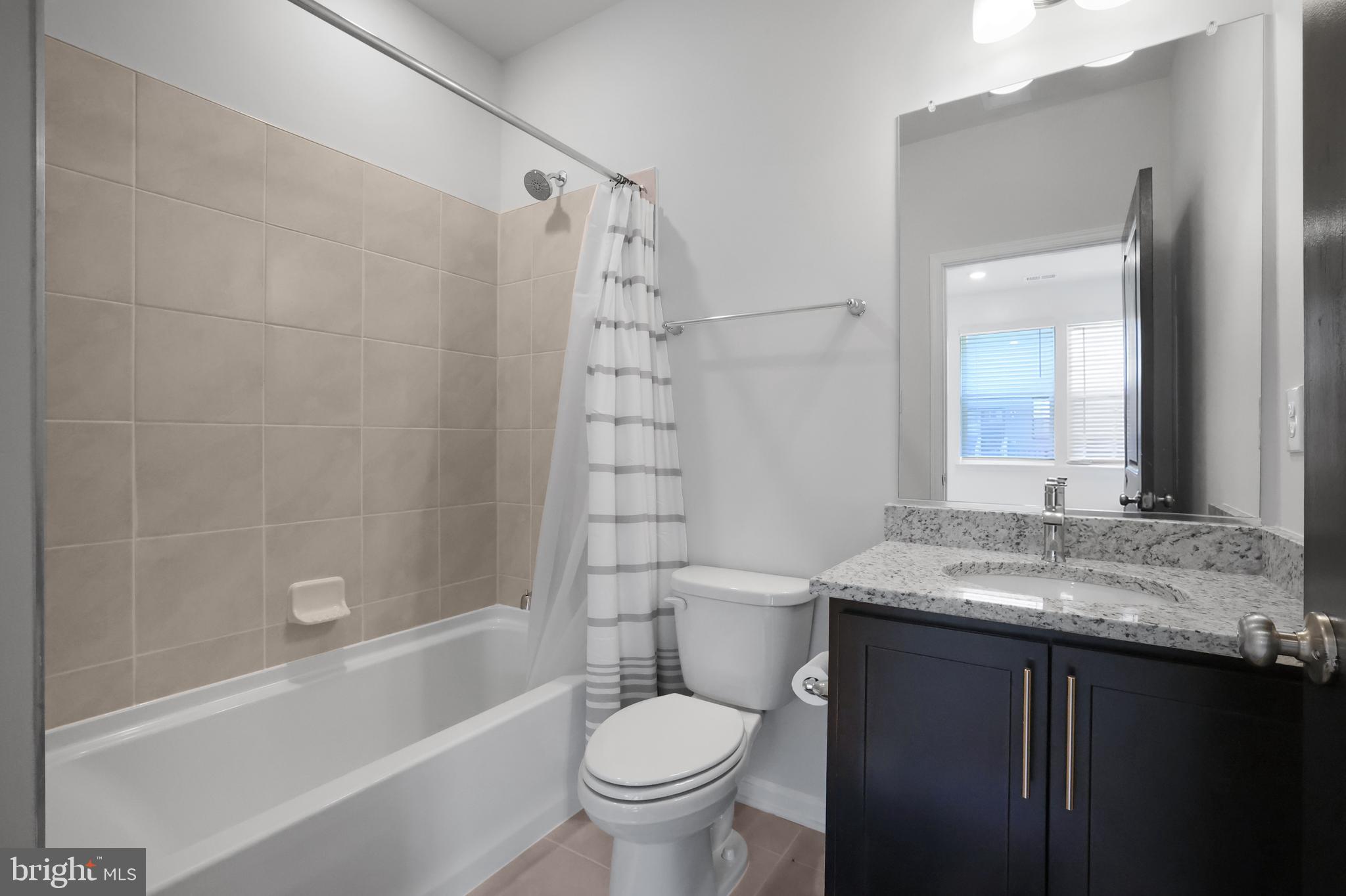854 Amity Street Frederick, MD 21701 - Photo 41 of 62 a bathroom with a granite countertop sink toilet and shower