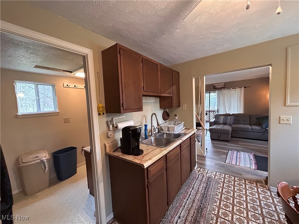 32290 Richey Lane Freeport, OH 43973 - Photo 13 of 20 Kitchen featuring wood finished floors, a sink, a textured ceiling, and light countertops