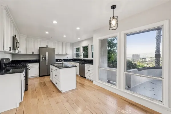 a kitchen with stainless steel appliances granite countertop a sink stove and refrigerator