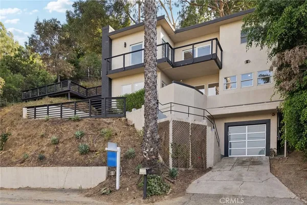 a view of an empty room with wooden floor and a fireplace