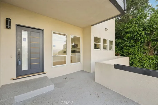 a view of an empty room with wooden floor and a fireplace