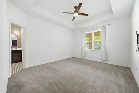 an empty room with windows and ceiling fan