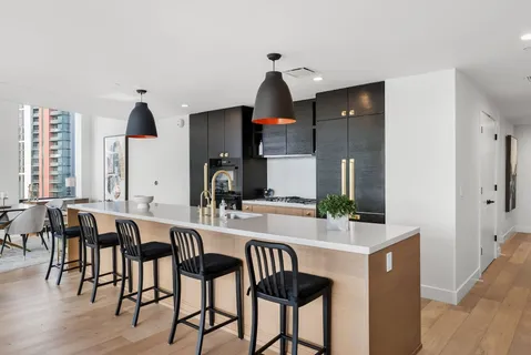 a large kitchen with stainless steel appliances a sink and a large window