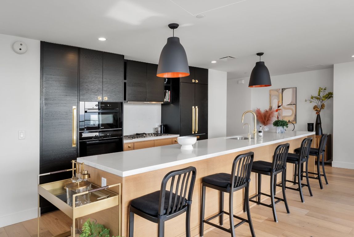 70 Rainey Street, Unit 2606 Austin, TX 78701 - Photo 11 of 37 a kitchen with granite countertop white cabinets and stainless steel appliances