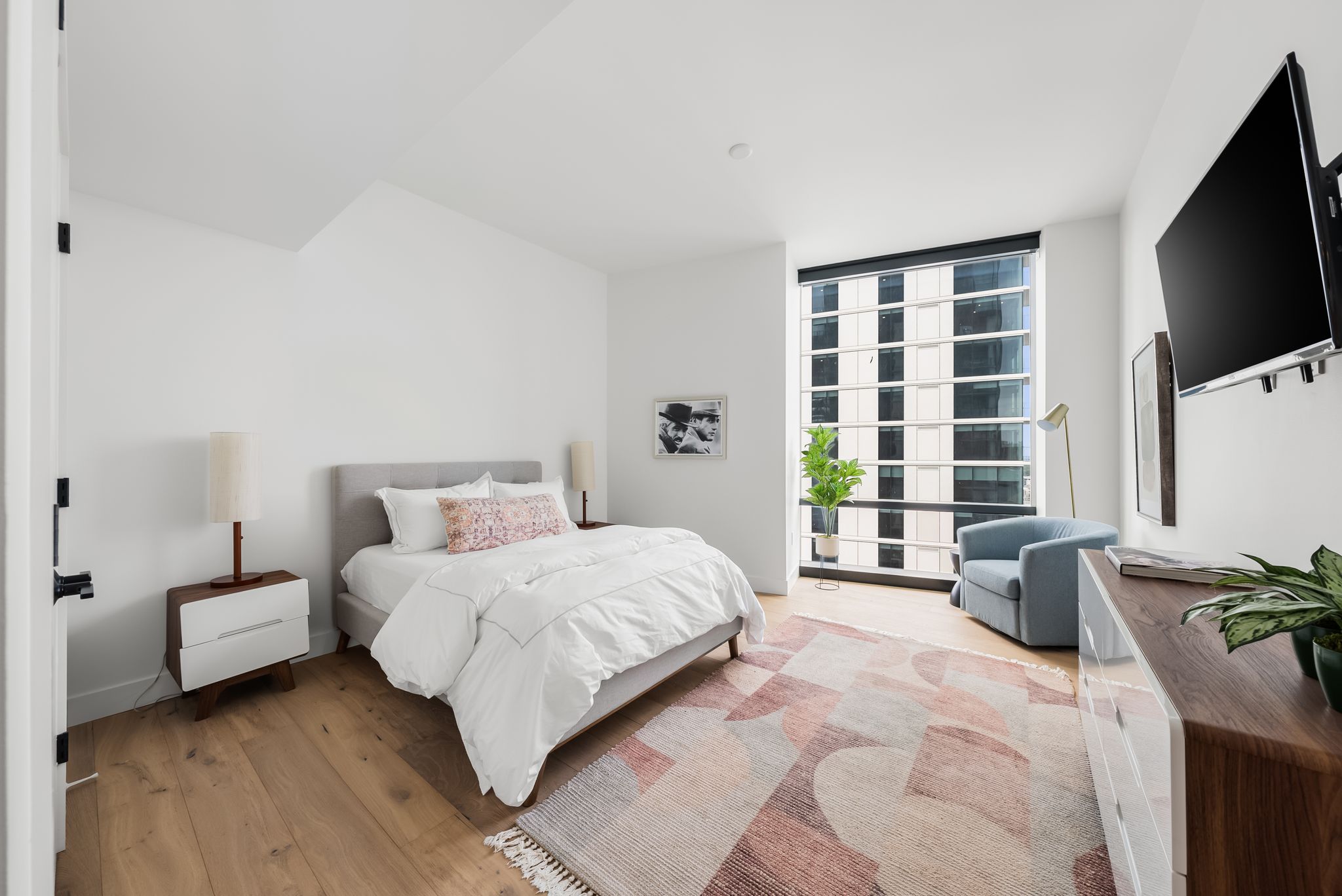 70 Rainey Street, Unit 2606 Austin, TX 78701 - Photo 22 of 37 a bedroom with a bed a flat screen tv and a couch