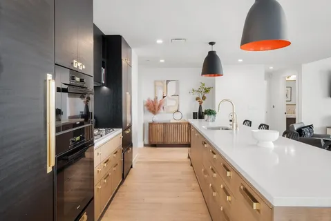 a large kitchen with stainless steel appliances a sink and cabinets