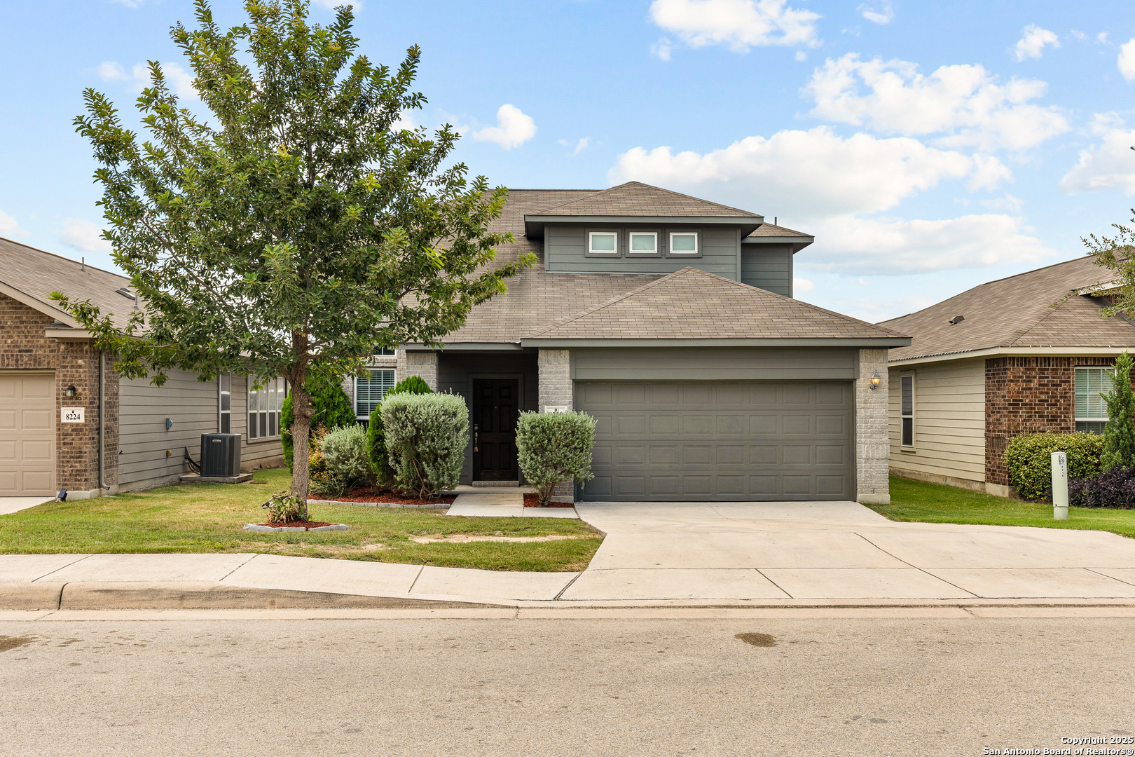 a front view of a house with a yard and garage