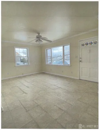 an empty room with windows and ceiling fan