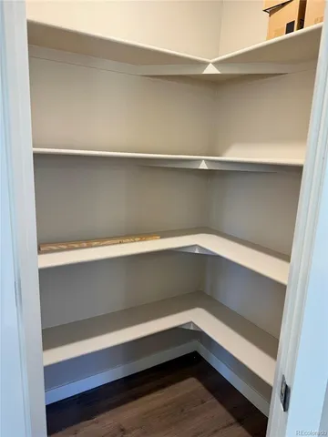 an empty room with wooden floor chandelier and entryway