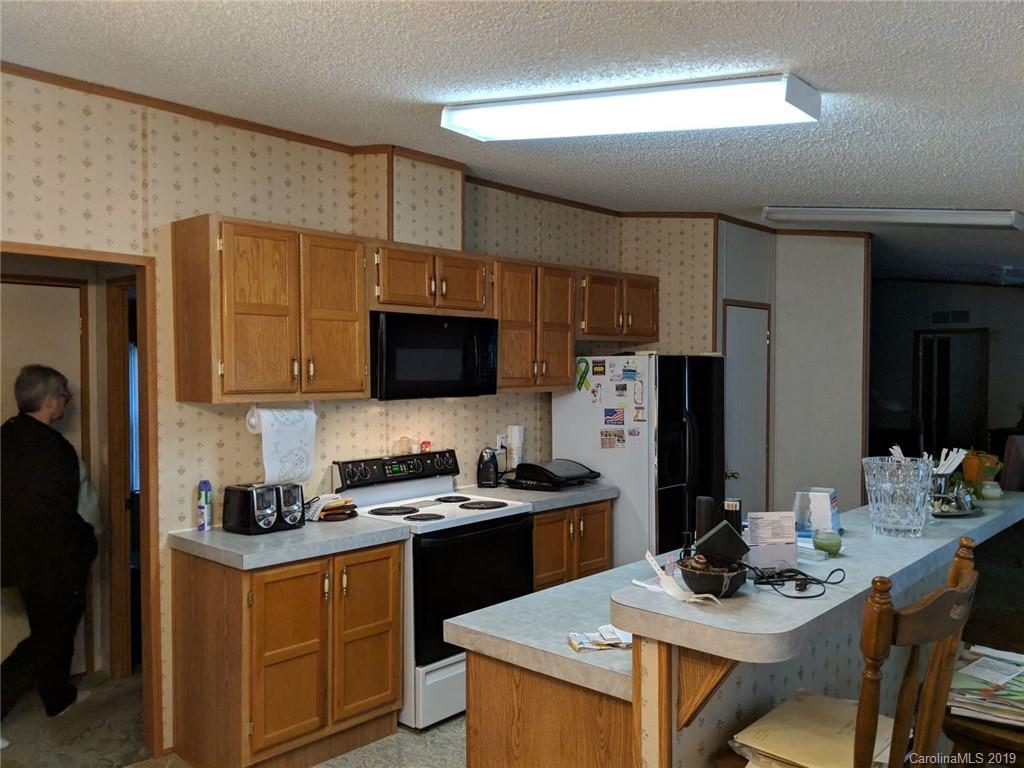 1090 State Rd S-46-1102 York, SC 29745 - Photo 5 of 10 a kitchen with stainless steel appliances kitchen island granite countertop a sink dishwasher a stove a refrigerator with a dining table and chairs