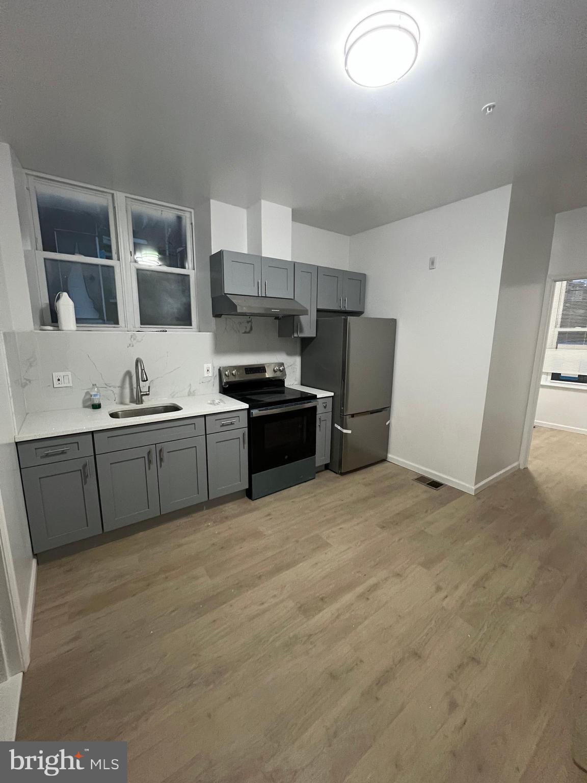 4422 Locust Street, Unit 1 2 Philadelphia, PA 19104 - Photo 17 of 30 a kitchen with stainless steel appliances granite countertop a stove a sink and a refrigerator