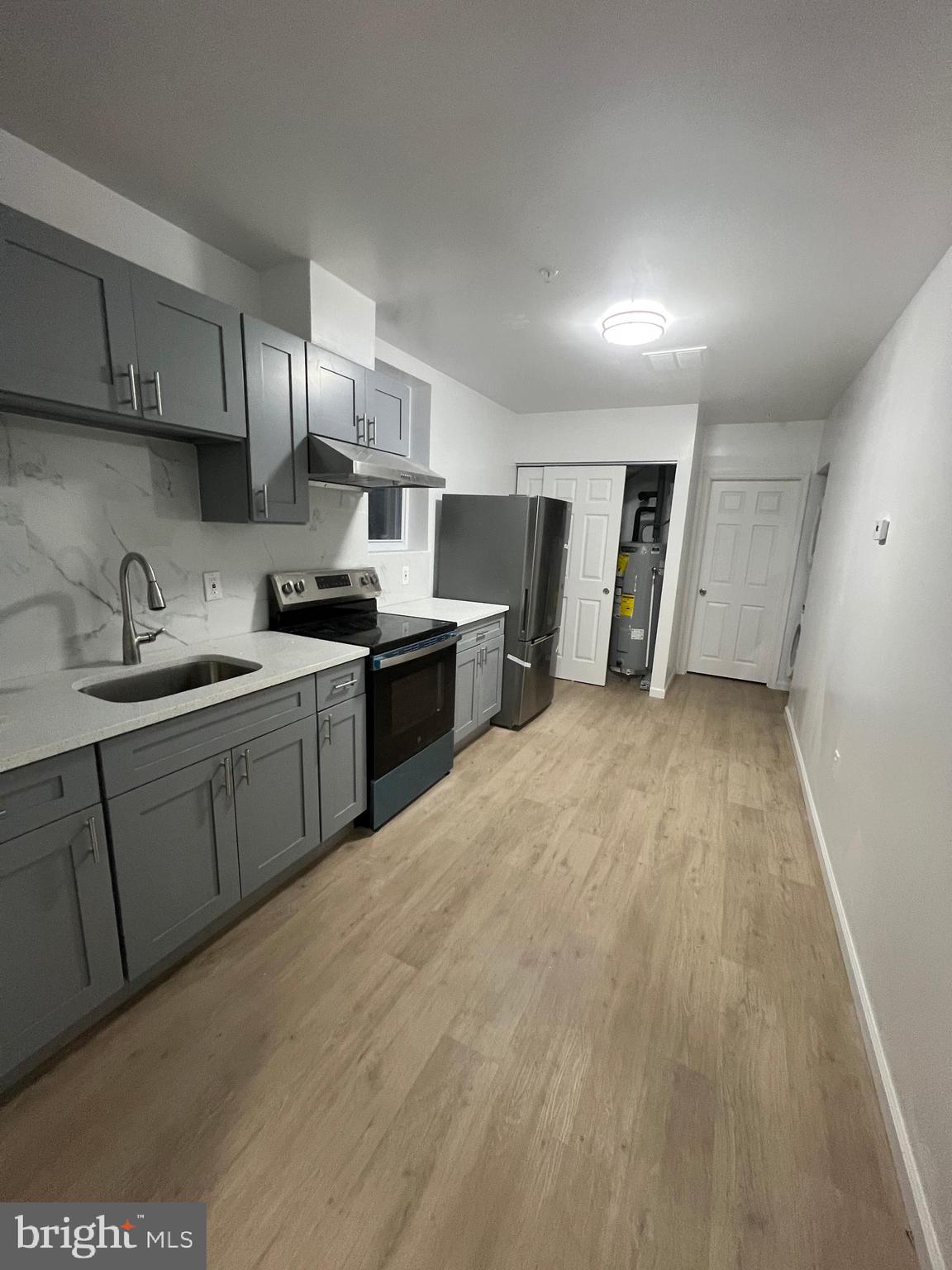 4422 Locust Street, Unit 1 2 Philadelphia, PA 19104 - Photo 19 of 30 a kitchen with stainless steel appliances granite countertop a sink dishwasher stove and refrigerator