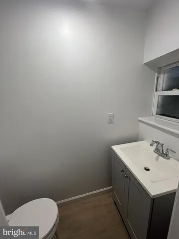 a view of an empty room with wooden floor and stairs