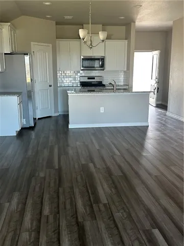 a kitchen with granite countertop a stove and a wooden floors