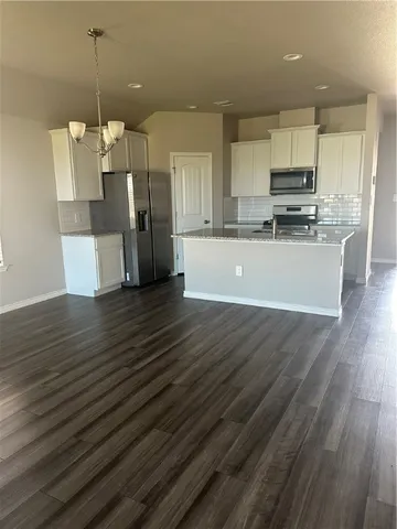 a view of a kitchen with cabinets stainless steel appliances and wooden floor