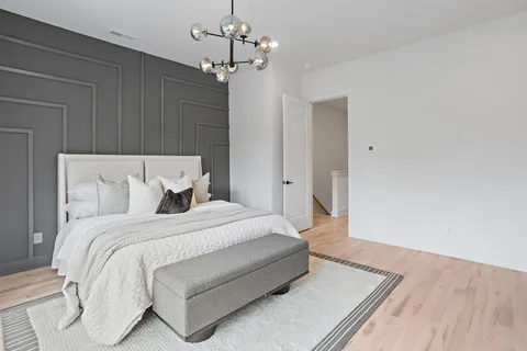 a spacious bedroom with a bed and a chandelier