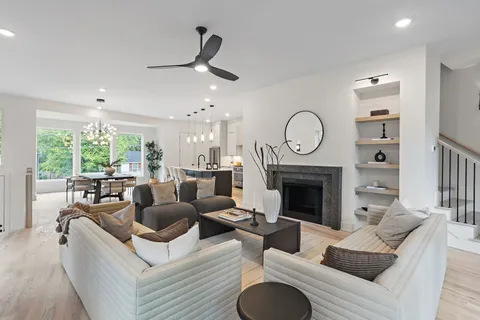 a living room with furniture a fireplace and a large window