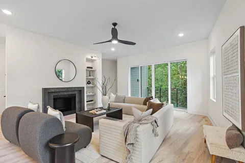 a living room with furniture a fireplace and a large window