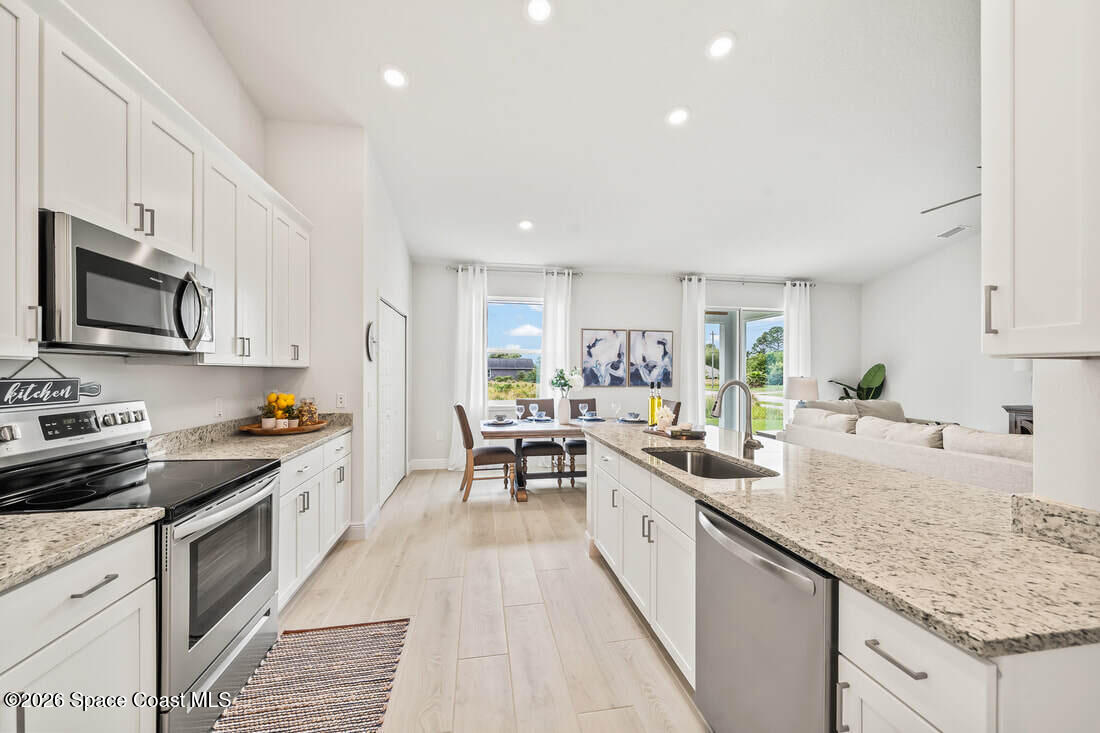 356 Altman Avenue Southeast Palm Bay, FL 32909 - Photo 11 of 27 a kitchen with granite countertop lots of counter top space a sink stainless steel appliances and cabinets