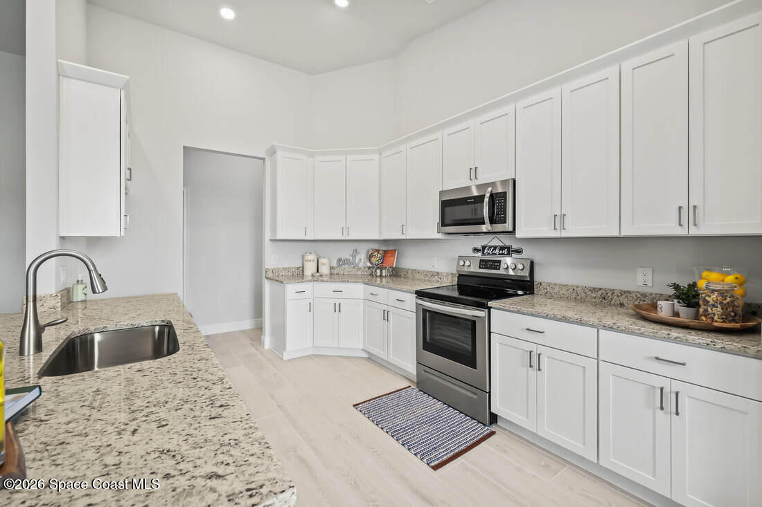356 Altman Avenue Southeast Palm Bay, FL 32909 - Photo 12 of 27 a kitchen with appliances a sink and cabinets