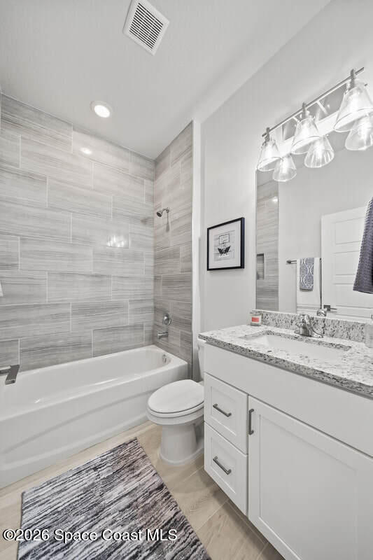 356 Altman Avenue Southeast Palm Bay, FL 32909 - Photo 17 of 27 a bathroom with a granite countertop sink a toilet a mirror and bathtub
