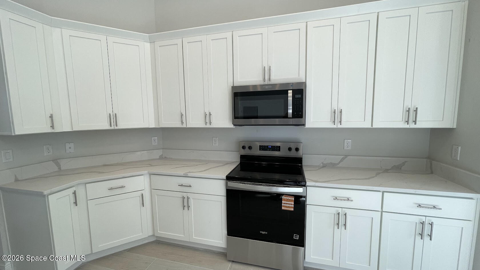 356 Altman Avenue Southeast Palm Bay, FL 32909 - Photo 24 of 27 a kitchen with white cabinets and black appliances