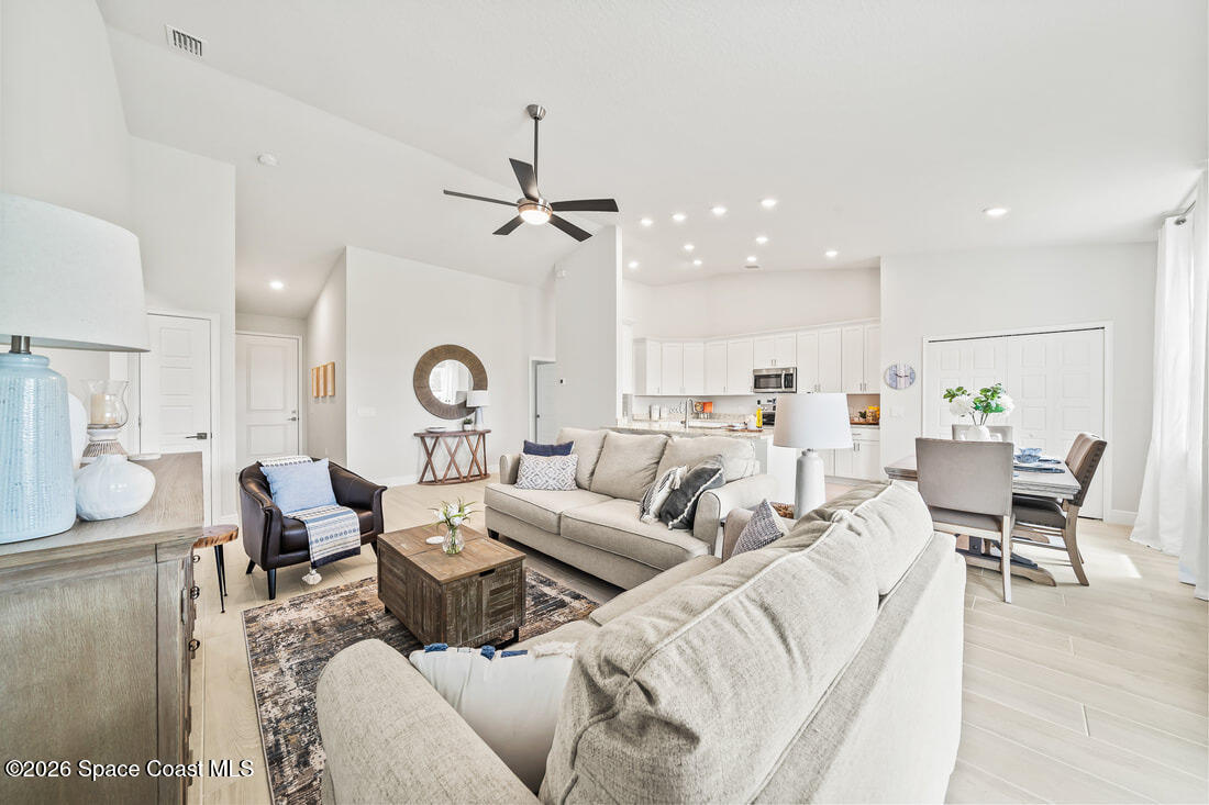 356 Altman Avenue Southeast Palm Bay, FL 32909 - Photo 6 of 27 a living room with furniture kitchen view and a chandelier