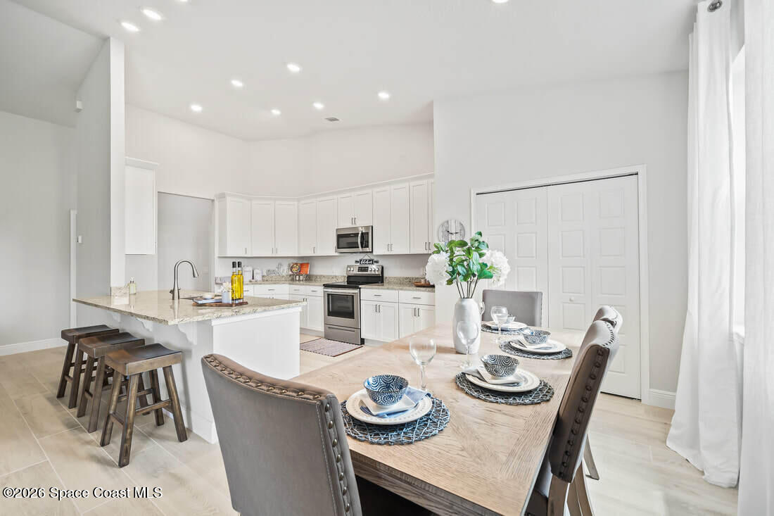 356 Altman Avenue Southeast Palm Bay, FL 32909 - Photo 8 of 27 a kitchen with granite countertop white cabinets and chairs
