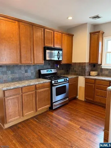 a kitchen with wooden floors and a stove top oven