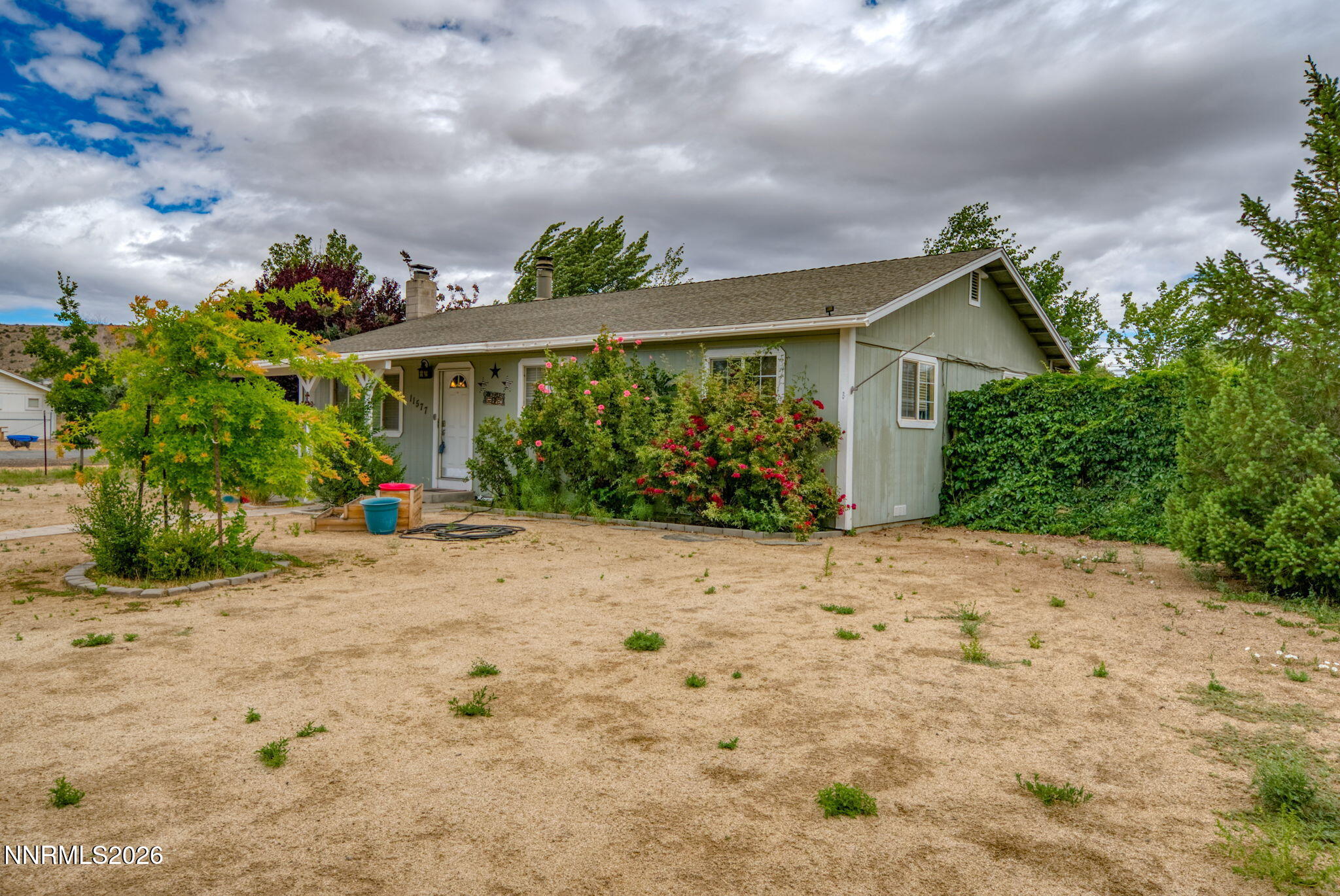 11577 Deodar Way Reno, NV 89506 - Photo 58 of 58 a front view of a house with a yard and potted plants