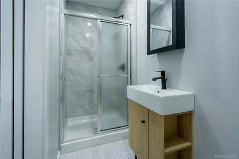 a bathroom with a shower sink and mirror