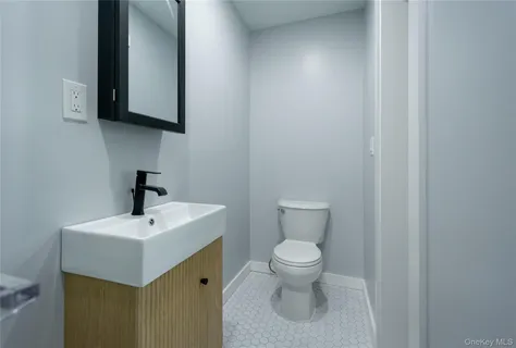 a bathroom with a toilet a sink and mirror