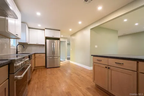 a kitchen with granite countertop a refrigerator and a sink