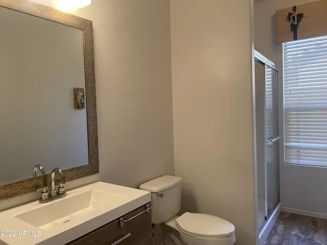 a bathroom with a sink a toilet and a mirror