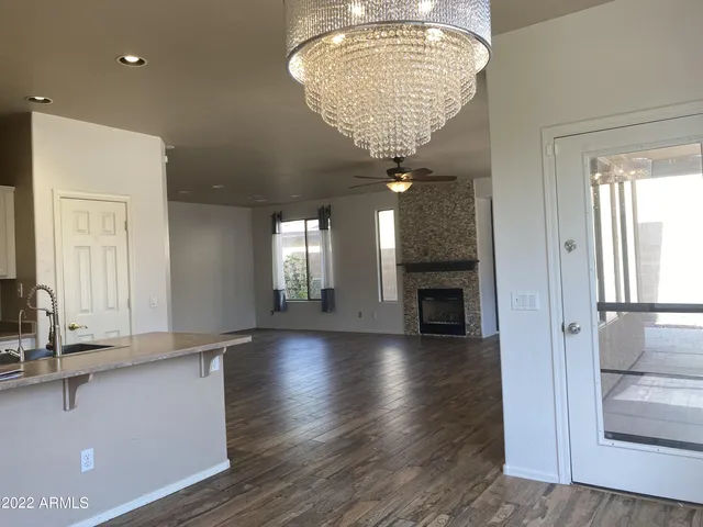 a view of a hallway with wooden floor and a chandelier
