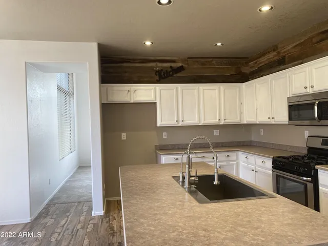 a kitchen with a sink a stove and cabinets
